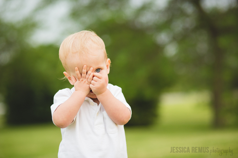 baby boy playing peekaboo photograph