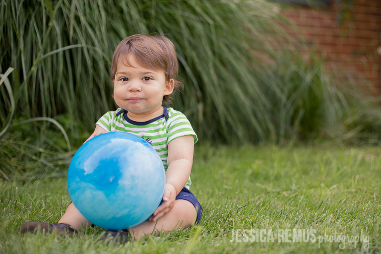 baby boy holding bouncy ball outside