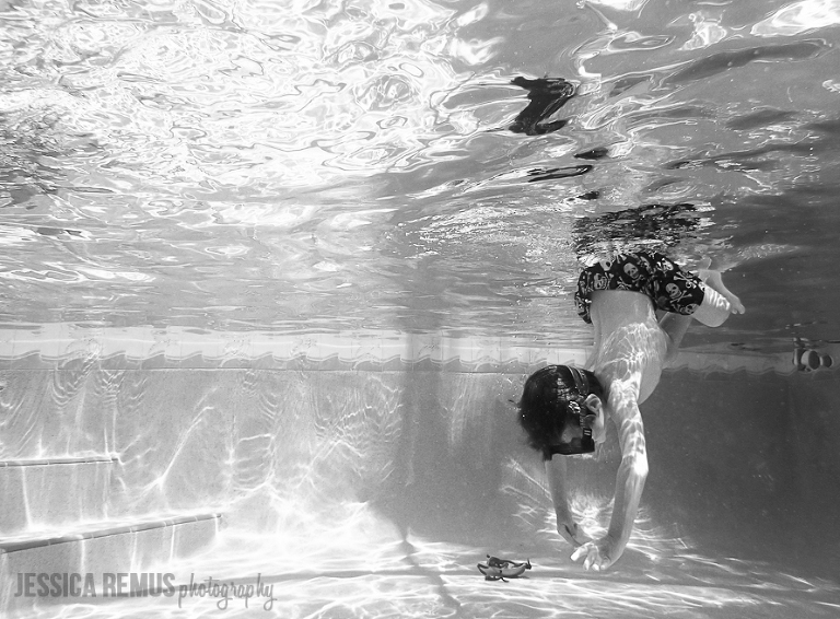 boy diving underwater in pool